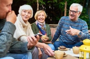 Gruppe vergnügter Senioren beim Kaffee - Online Kontakte knüpfen für Neueinsteiger