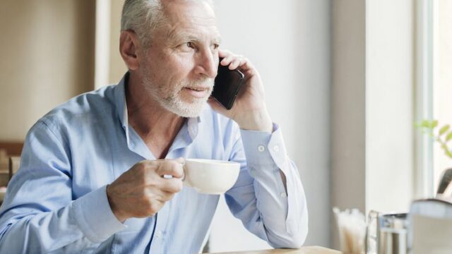 reifer-mann-am-telefon-mit-teetasse-1.jpg